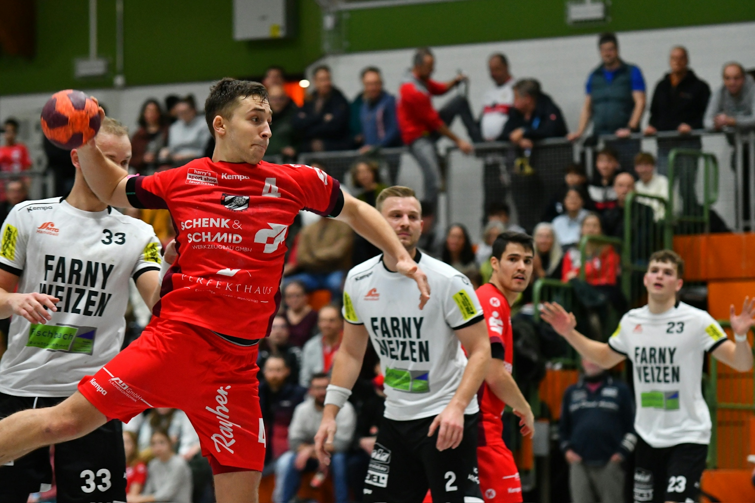 Handballspieler des HRW-Laupheim in rotem Trikot kurz vor dem Abwurf.